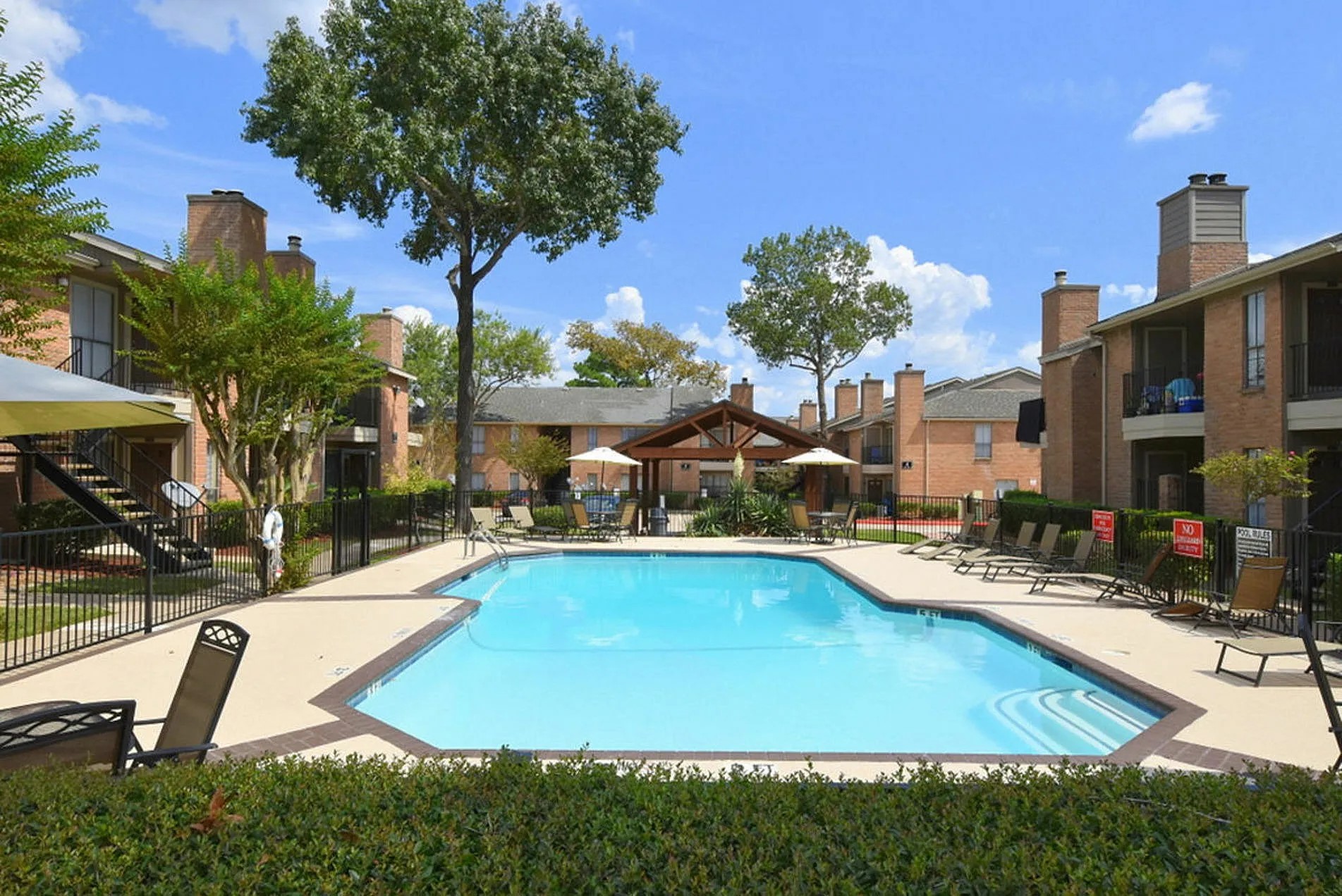 1230 Farm To Market 1960 Bypass Road East, Unit 723 Humble, TX 77338 - Photo 9 of 20 a view of a swimming pool with a table and chairs under an umbrella