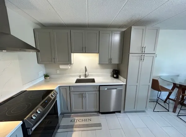a kitchen with stainless steel appliances a stove a sink and a refrigerator