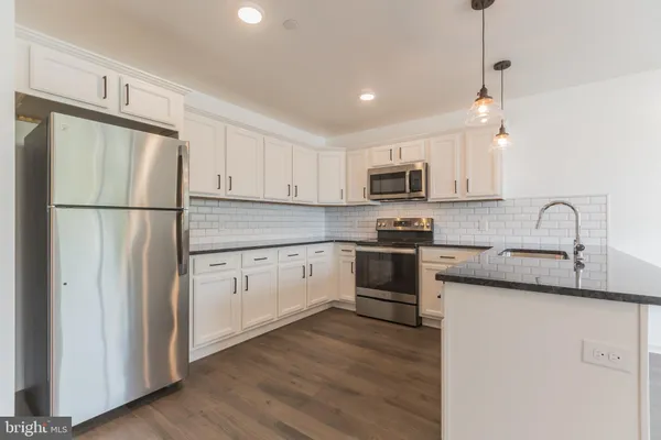 a kitchen with granite countertop white cabinets and white appliances