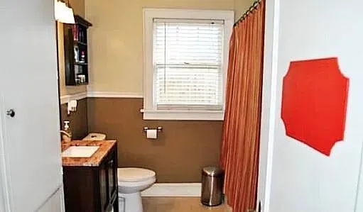 a bathroom with a toilet a sink and a mirror