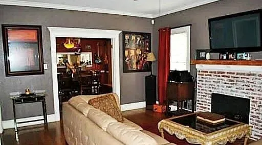 a living room with furniture a flat screen tv and a fireplace