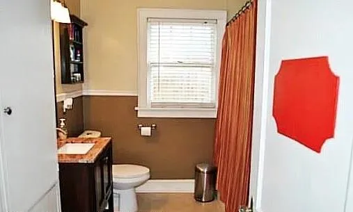 a bathroom with a toilet sink and mirror