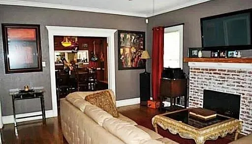 a living room with furniture a flat screen tv and a fireplace