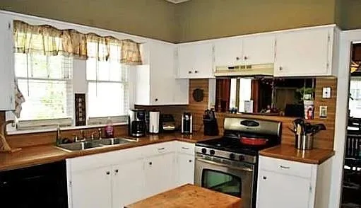 a kitchen with a sink a stove and cabinets