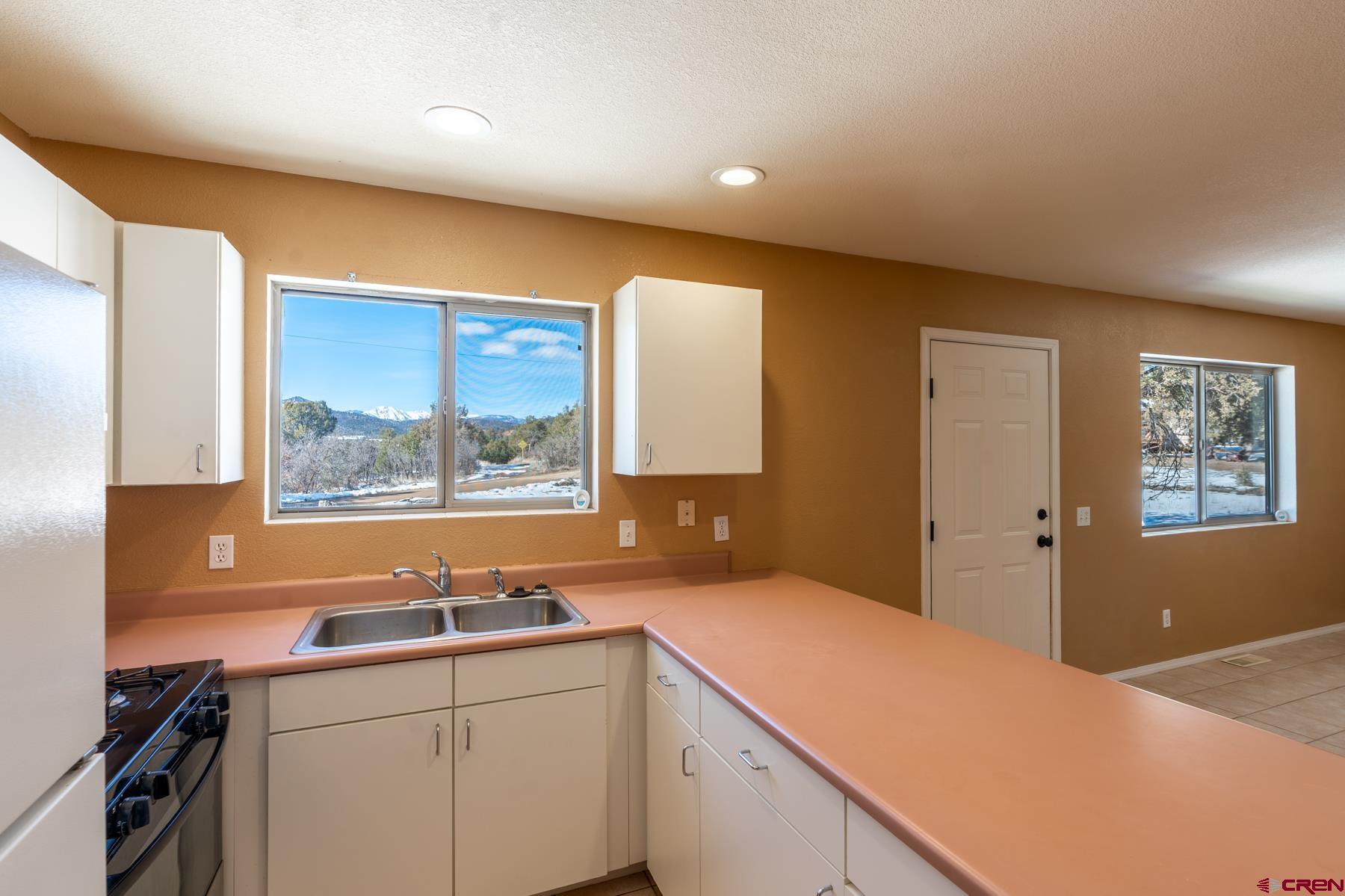 190 Pine Ridge Road Durango, CO 81301 - Photo 19 of 27 a kitchen with a sink cabinets appliances and a window