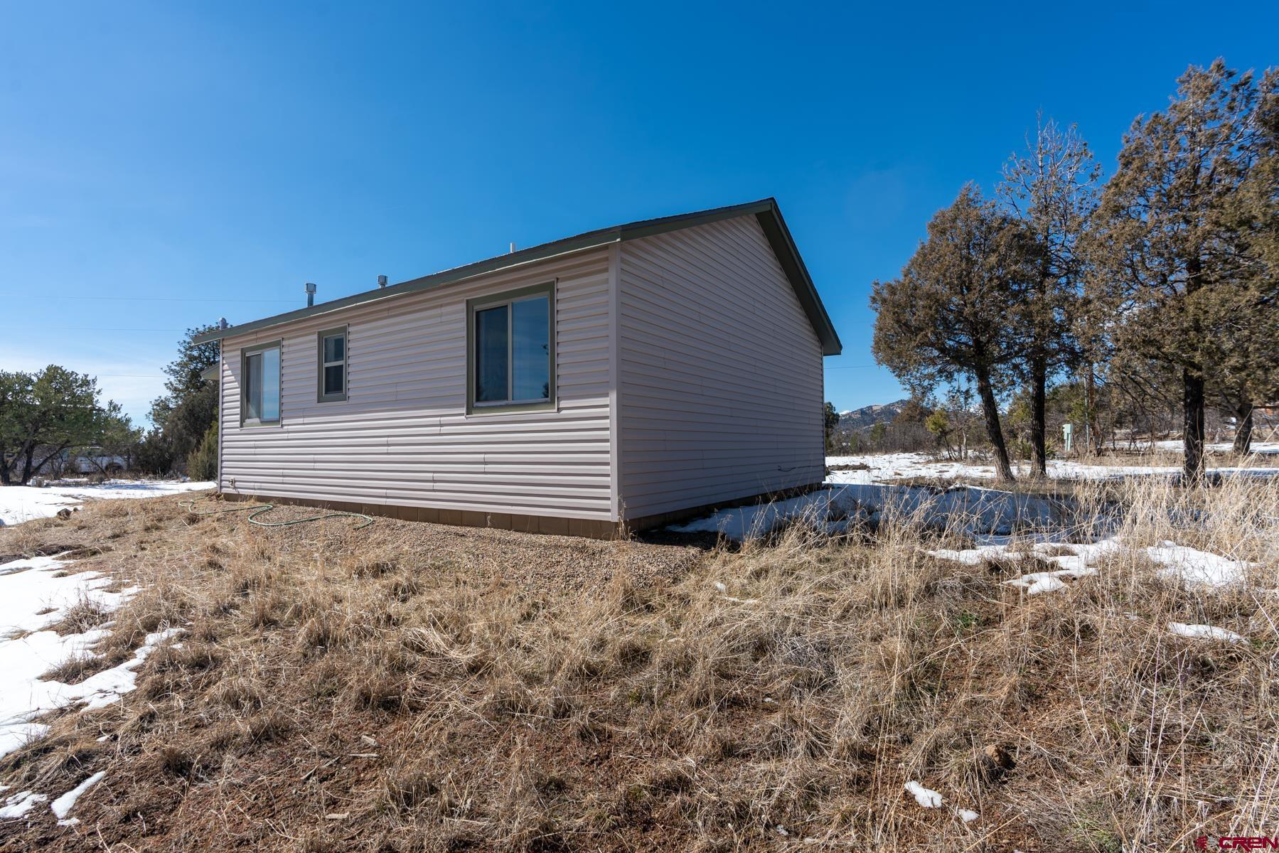 190 Pine Ridge Road Durango, CO 81301 - Photo 24 of 27 a backyard of a house with large trees