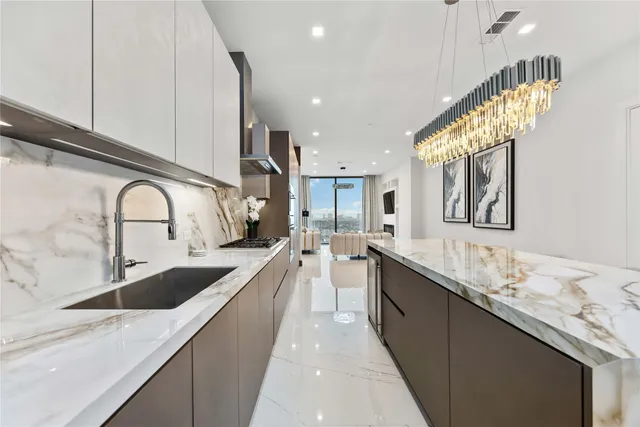 a living room with furniture and a flat screen tv with kitchen view