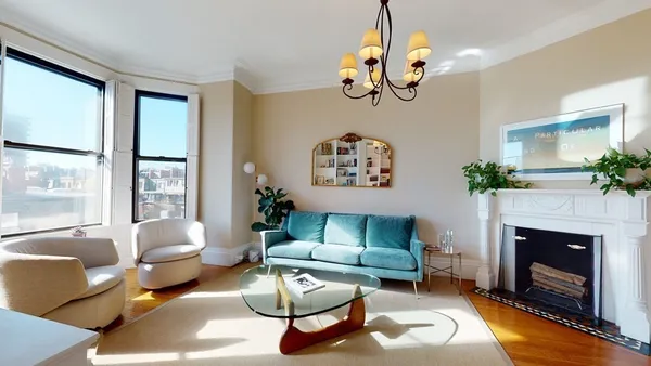 a living room with furniture chandelier and a fireplace