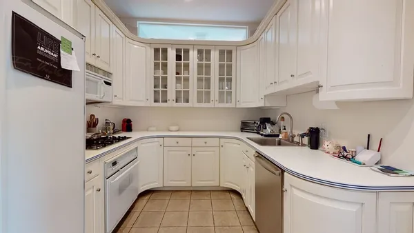 a kitchen with white cabinets and white appliances