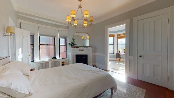 a spacious bedroom with a bed and a chandelier
