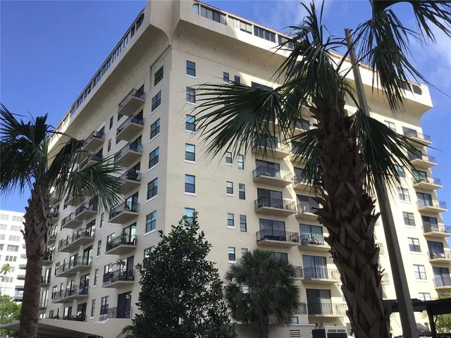 a front view of a building with palm trees