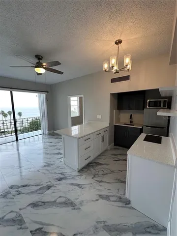 a view of kitchen with sink microwave and refrigerator