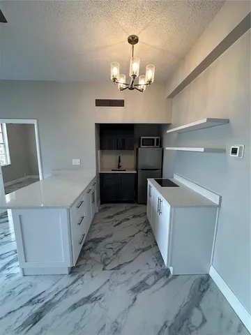 a kitchen with granite countertop a sink and cabinets