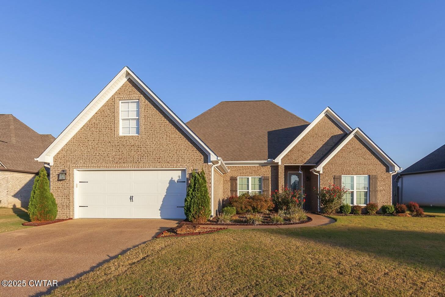 a front view of a house with yard and garage