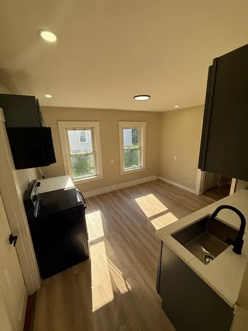 a living room with hard wood floors and a sink