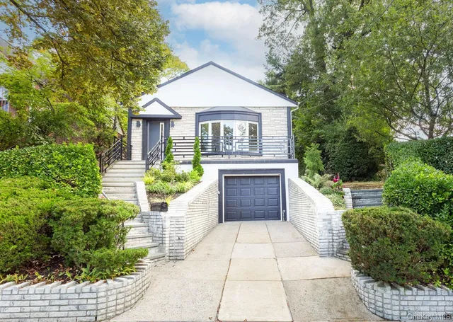 a front view of a house with a yard and potted plants