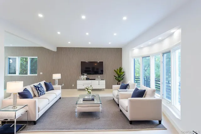 a living room with furniture flat screen tv and a large window