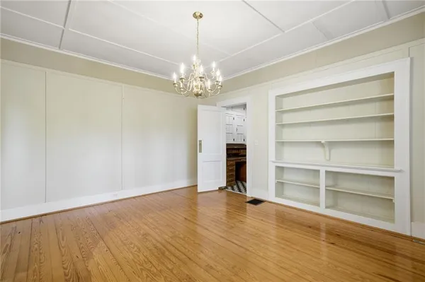 a view of an empty room with a window and wooden floor