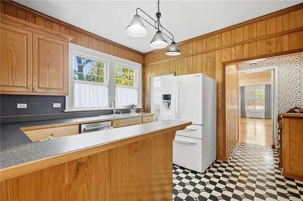 a kitchen with stainless steel appliances a refrigerator a sink and white cabinets