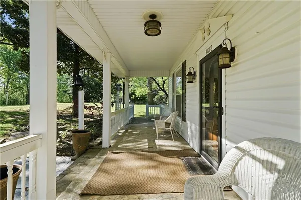 a view of a porch with furniture and floor to ceiling window