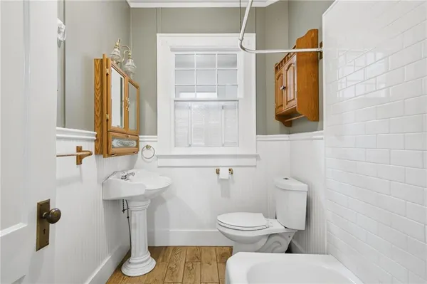 a bathroom with a toilet sink and mirror