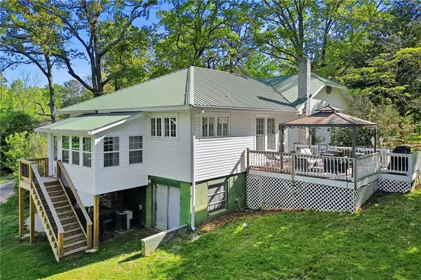 a aerial view of a house with a yard deck and a large tree