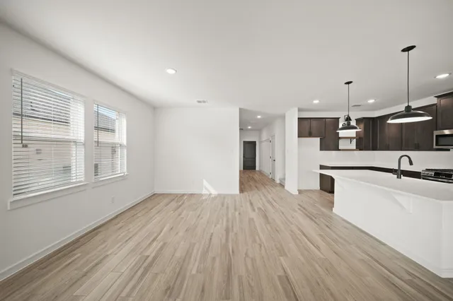 a large kitchen with stainless steel appliances kitchen island a large counter top and a wooden floors