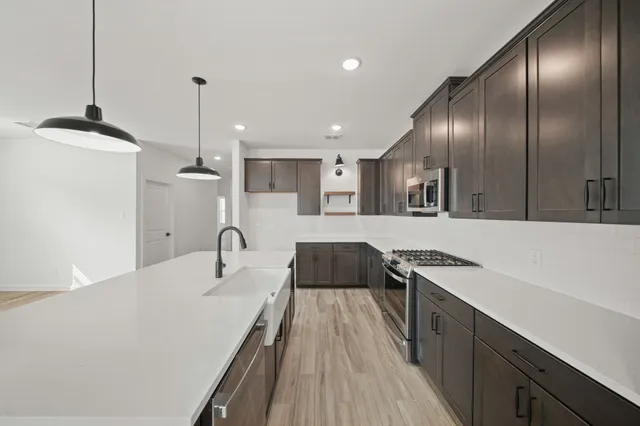 a kitchen with granite countertop cabinets a sink a counter space and stainless steel appliances