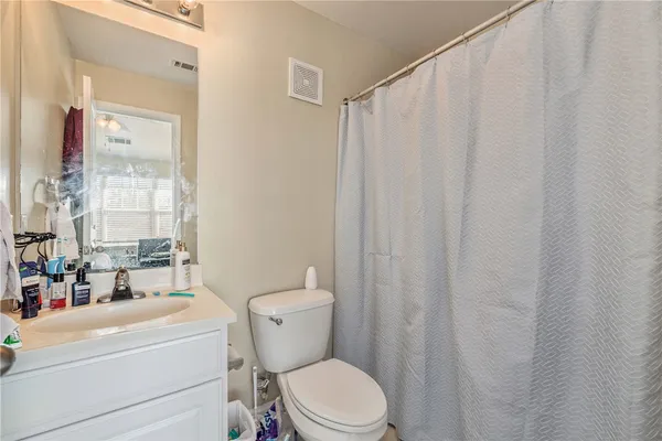 a bathroom with a toilet a sink and a shower curtain