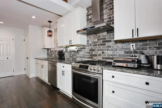a kitchen with granite countertop cabinets stainless steel appliances and a sink