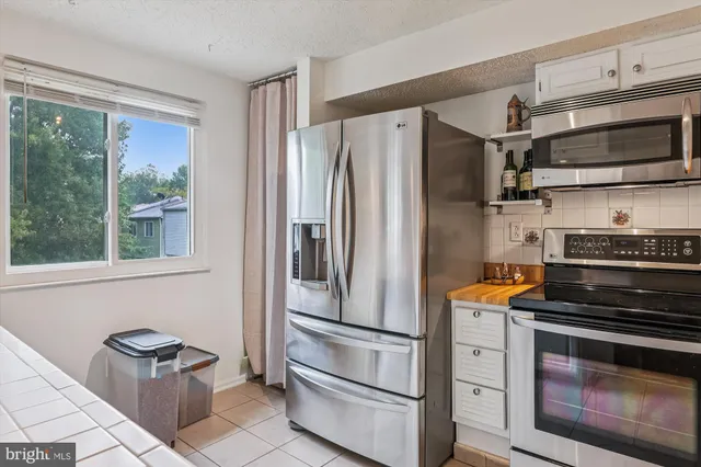 a kitchen with stainless steel appliances a stove a microwave and a refrigerator