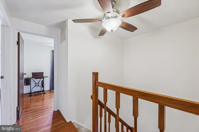 a view of a hallway with wooden floor and workspace