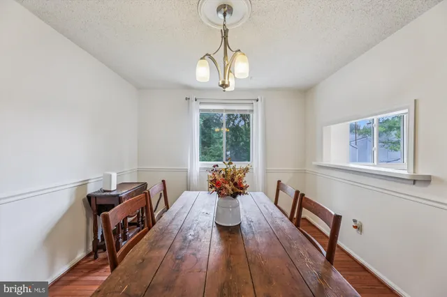 a dining room with furniture a chandelier and wooden floor