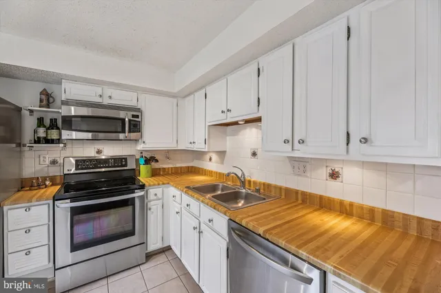 a kitchen with granite countertop a stove sink and microwave