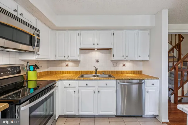 a kitchen with granite countertop a sink a stove and cabinets