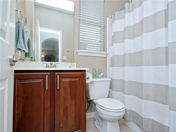 a bathroom with a granite countertop toilet sink and mirror