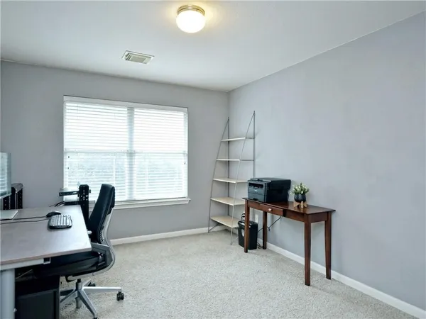 a view of a workspace with furniture and a window