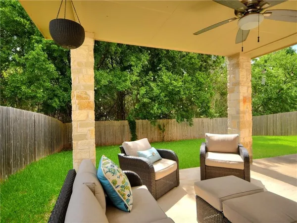 a view of a patio with couches chairs potted plants and a palm tree