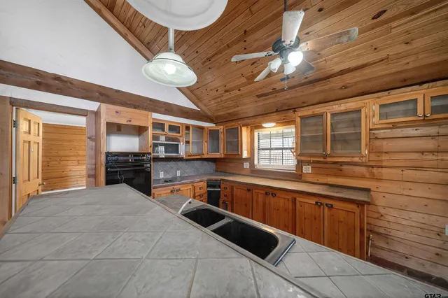 a large kitchen with stainless steel appliances granite countertop a sink and cabinets
