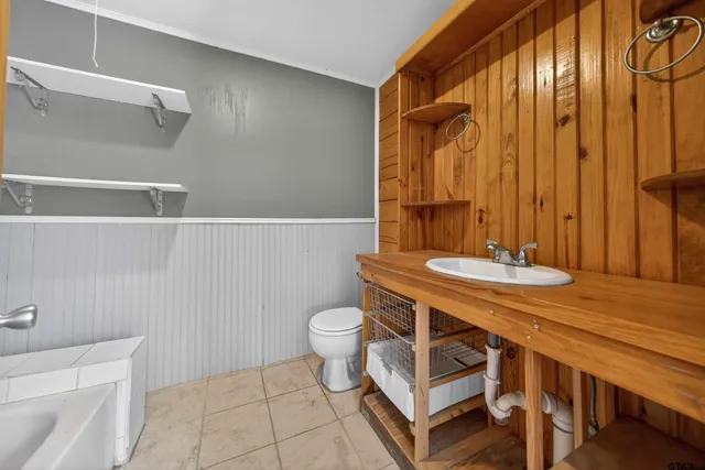 a bathroom with a sink a toilet a mirror and shower