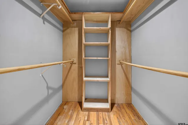 a view of walk in closet with empty racks
