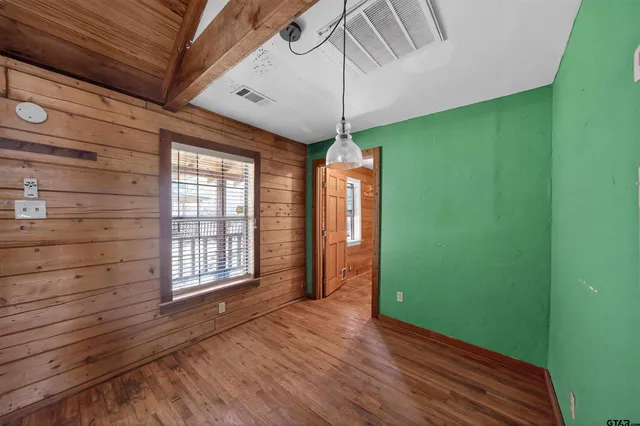 a view of a backyard with a large tree and wooden fence