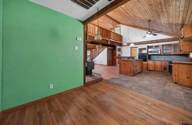 a view of empty room with wooden floor and ceiling fan