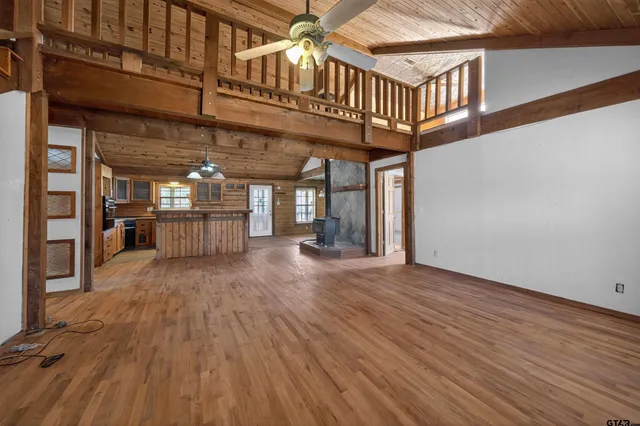 an empty room with wooden floor and a book shelf