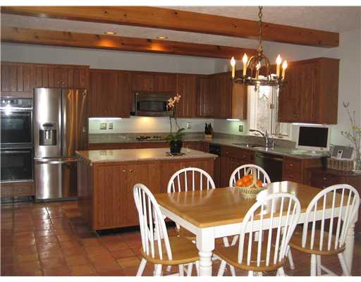 Kitchen. Recently updated, spacious eat-in kitchen with granite island and countertops with sleek stainless & black appliances. There are an abundance of cabinetry and pantry space.Enjoy access from kitchen out to screen porch.