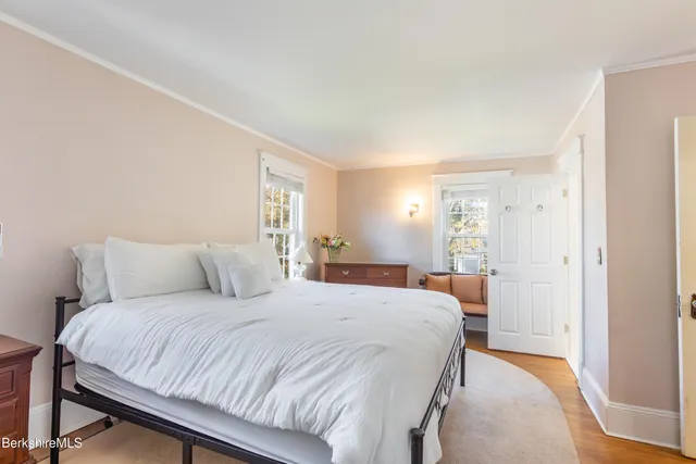 a bedroom with a large bed and a wooden floor