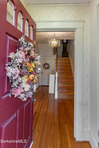 a kitchen with stainless steel appliances granite countertop a refrigerator a stove and a sink with wooden floor