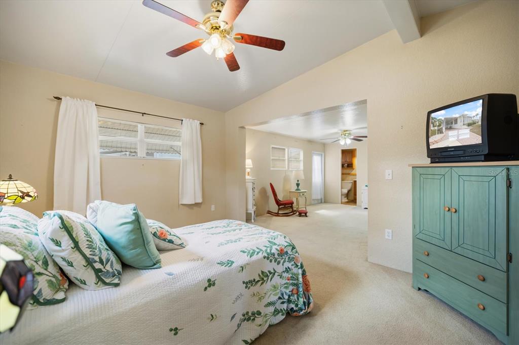 5791 Orange Blossom Road Venice, FL 34293 - Photo 16 of 55 a bedroom with a bed and a chandelier