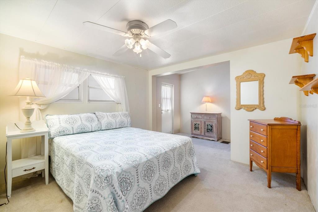 5791 Orange Blossom Road Venice, FL 34293 - Photo 19 of 55 a spacious bedroom with a bed and a chandelier
