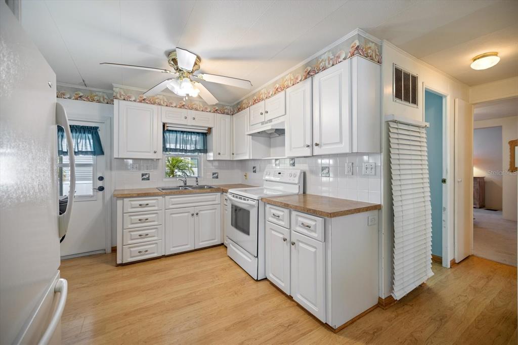 5791 Orange Blossom Road Venice, FL 34293 - Photo 4 of 55 a kitchen with white cabinets stainless steel appliances and window